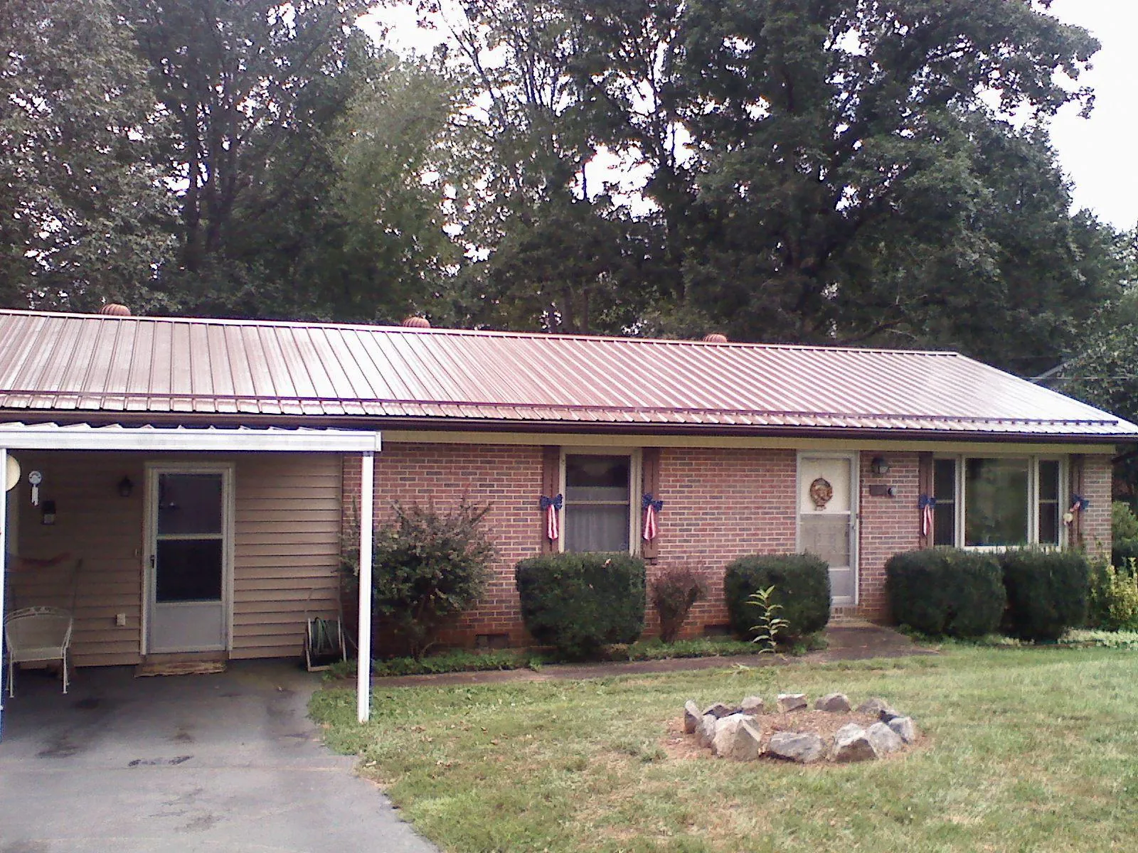 Bronze metal roof and carport on a brick ranch home — Roof Repair work by our crew in Georgetown